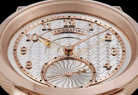 Rose gold watch face with intricate details and silver dial